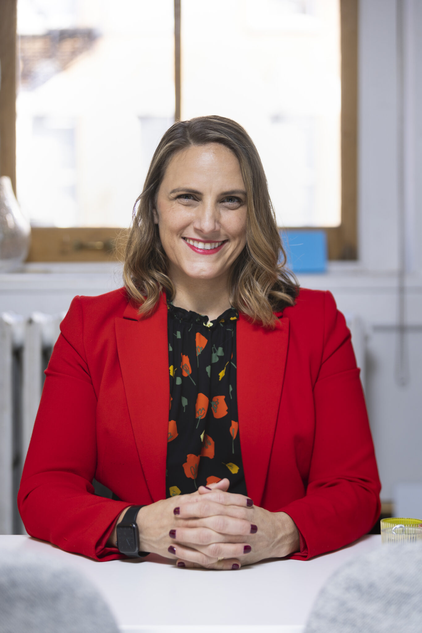 Glennda Testone — CEO, Nonprofit Leadership Lab Professional headshot of Glennda Testone, smiling and wearing a red blazer, set against a soft, neutral background.